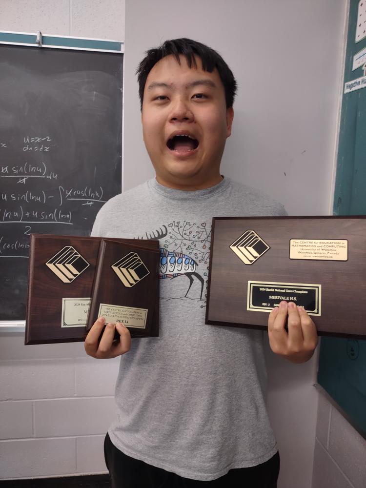 Rex holding math contest plaques